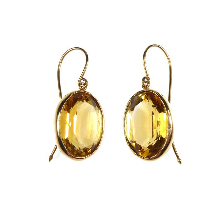 Pair of oval citrine and gold drop earrings, open collet set in gold with facetted cut stones